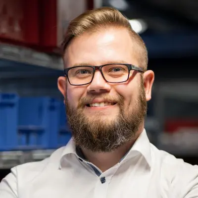 Smiling bearded man wearing glasses and white shirt