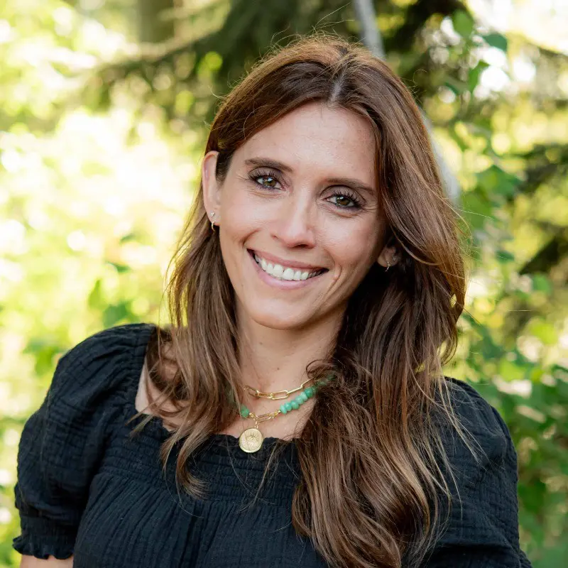 Smiling woman outdoors with green background