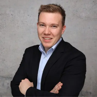 Smiling person in suit with folded arms