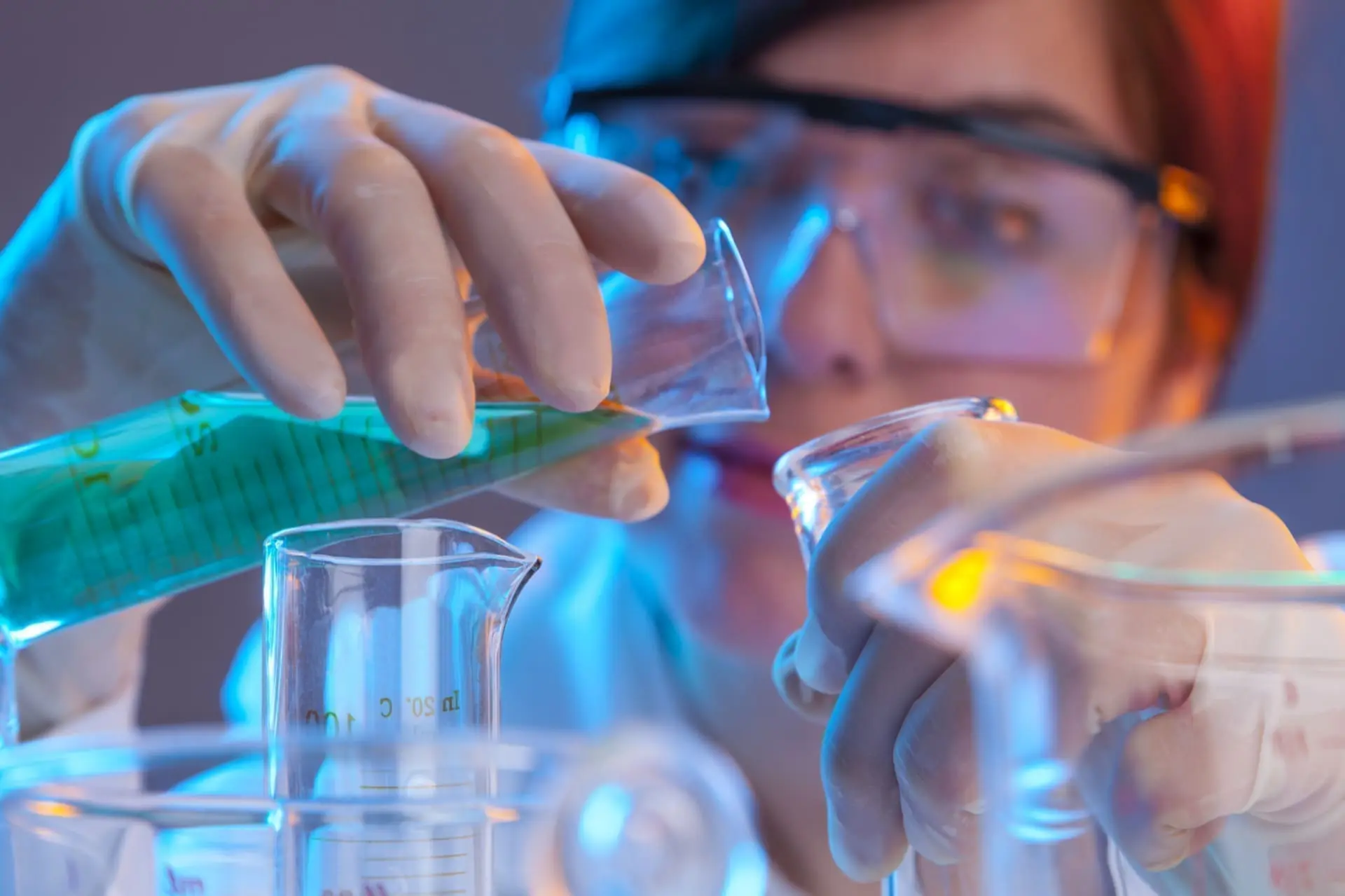 Scientist pouring liquid into beaker in laboratory.
