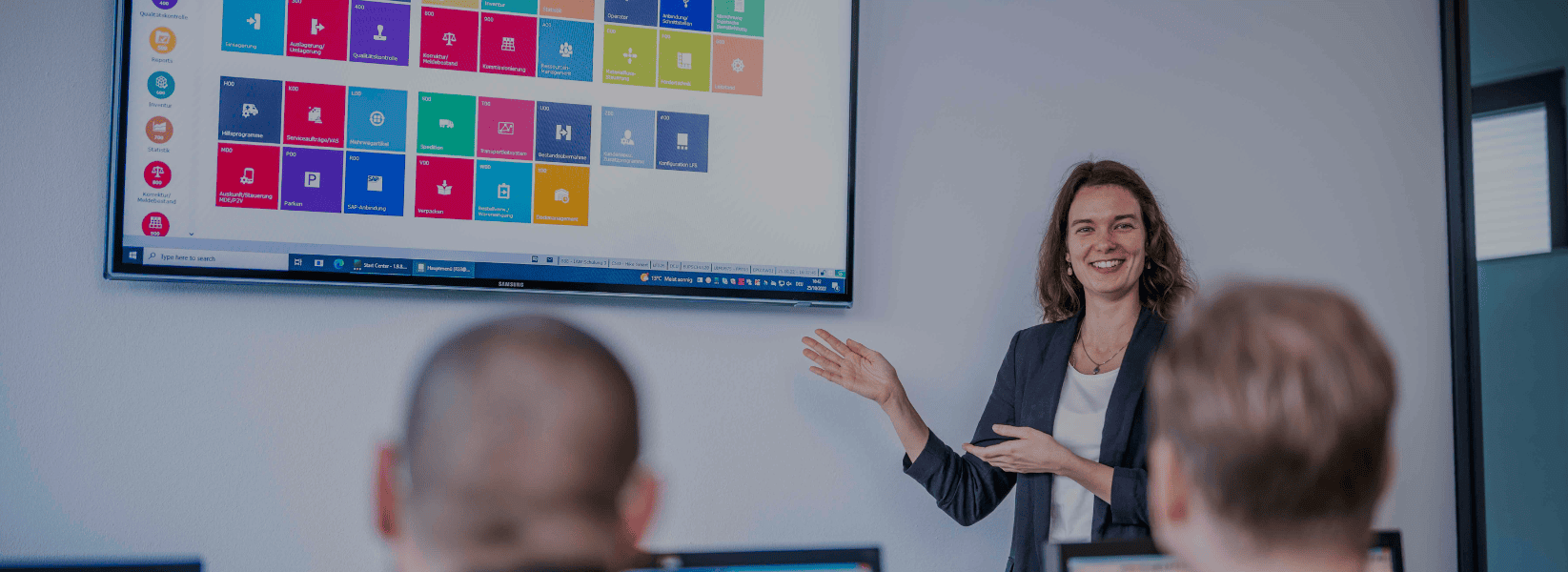 Presenter explaining software on screen to audience.
