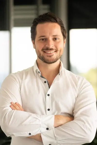 Smiling man in white shirt with crossed arms