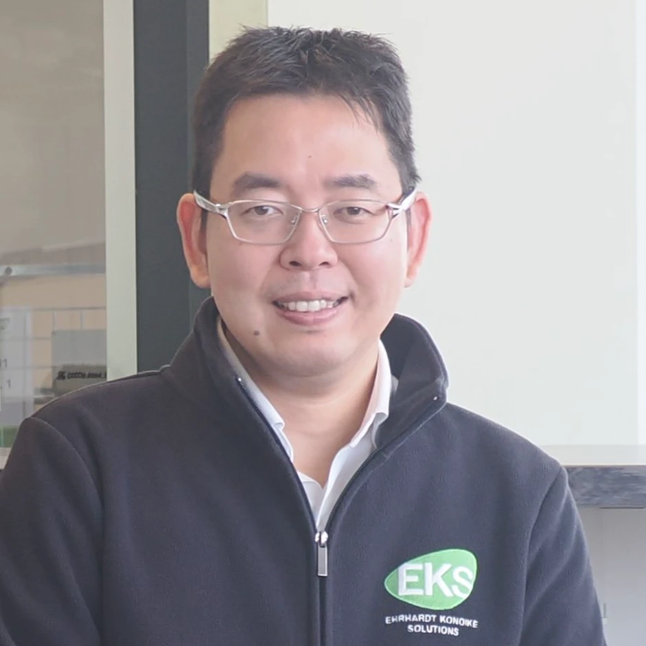 Smiling man wearing EKS-branded jacket and glasses