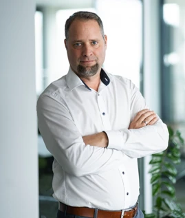 Man in white shirt standing with arms crossed