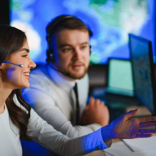 Two operators discussing map on computer screens.