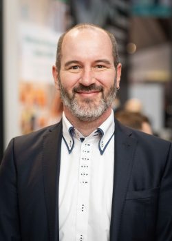 Mann im Anzug lächelt in die Kamera